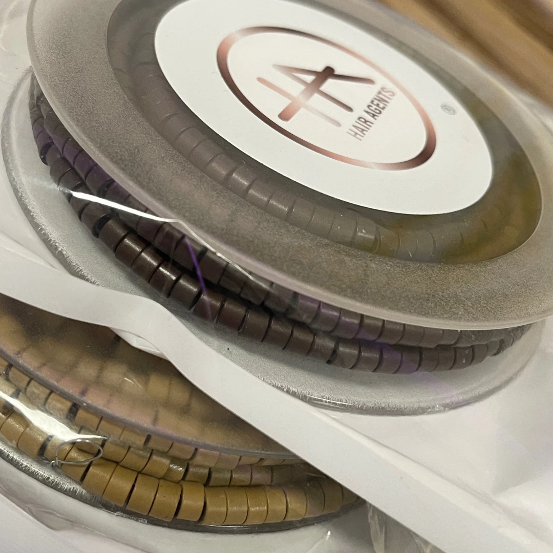Nahaufnahme von Microringen in braun und hellbraun zur Befestigung einer Butterfly Tresse die von Hair Agents hergestellt